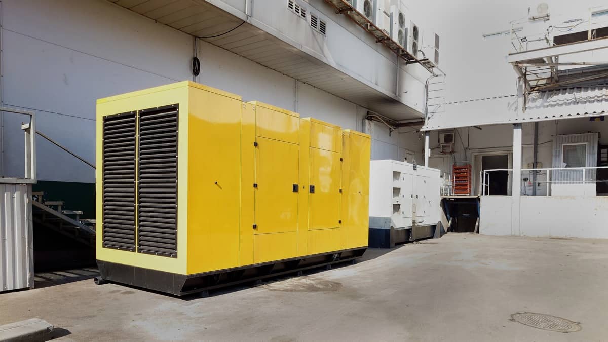 Un generator galben mare amplasat într-o curte industrială