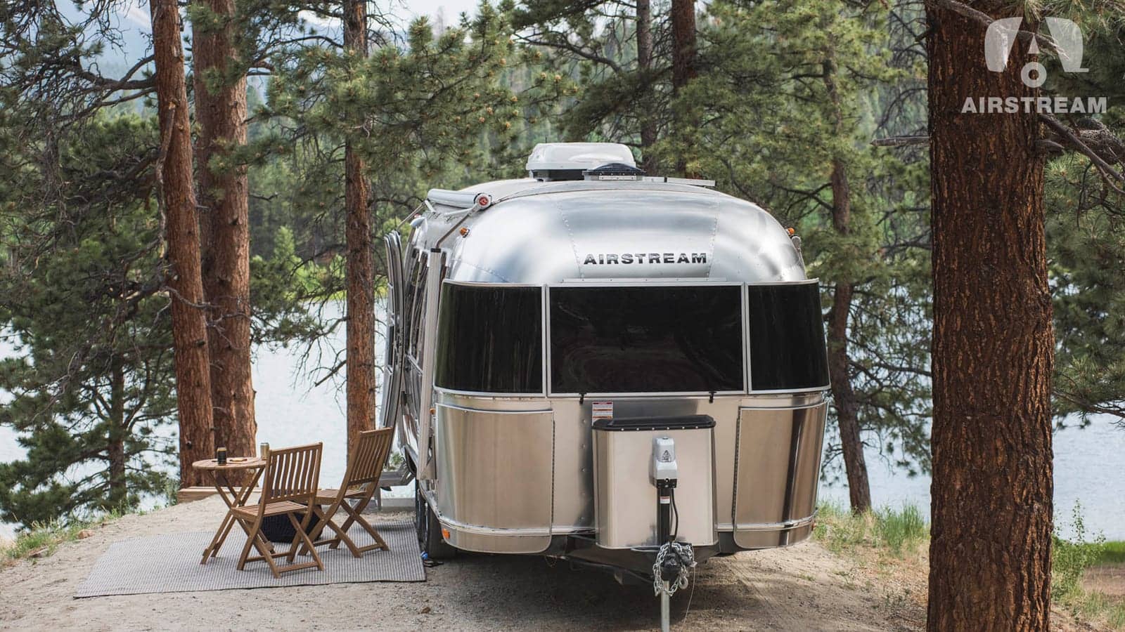 Rulotă de călătorie Airstream într-un camping din pădure